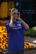 Woman wearing sunglasses in front of a market stall with flowers