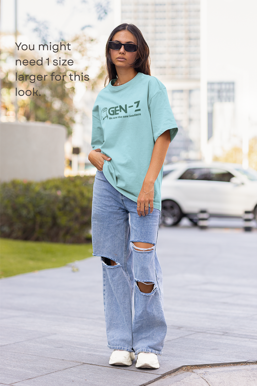 Person wearing a light blue t-shirt with 'GEN-Z' text and ripped jeans on a city street.