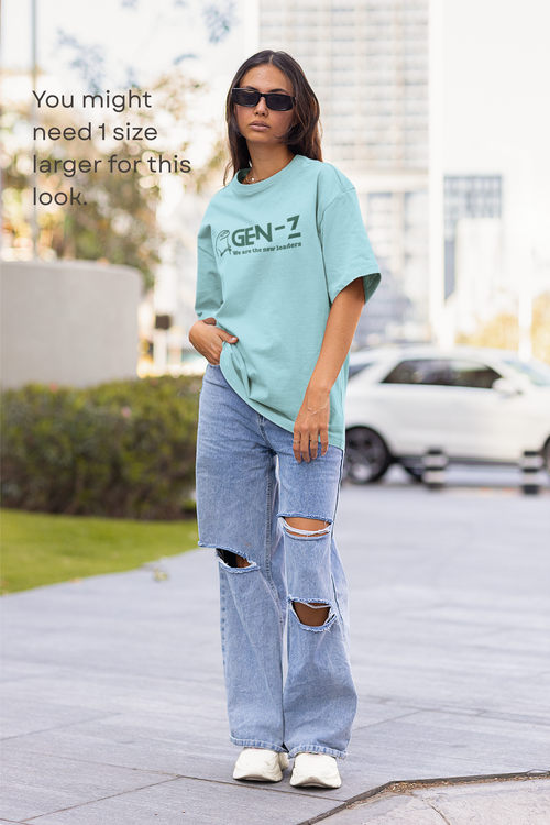 Person wearing a light blue t-shirt with 'GEN-Z' text and ripped jeans on a city street.