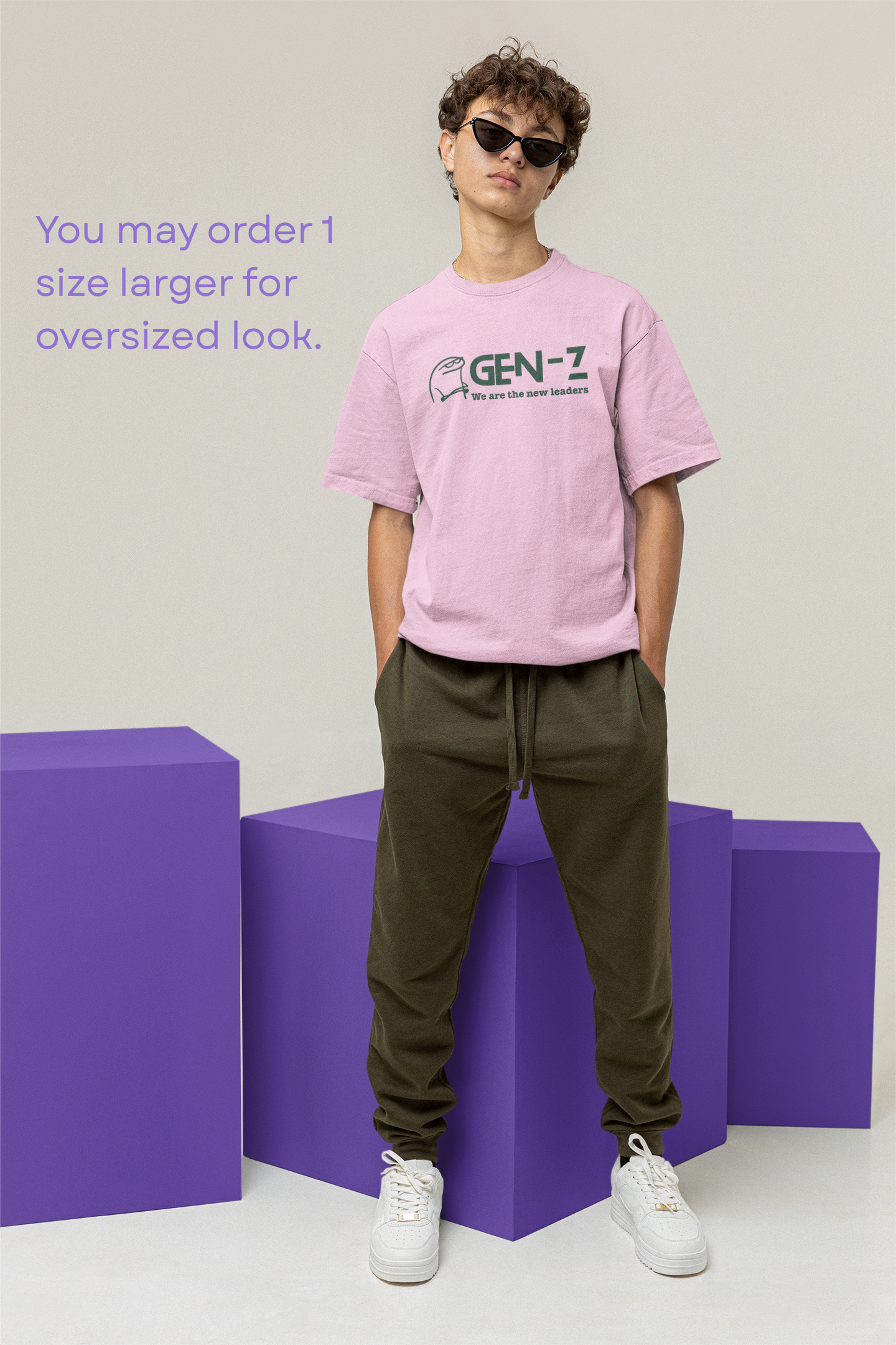 Person wearing a pink 'GEN-Z' t-shirt and green pants standing on purple blocks against a light gray background.