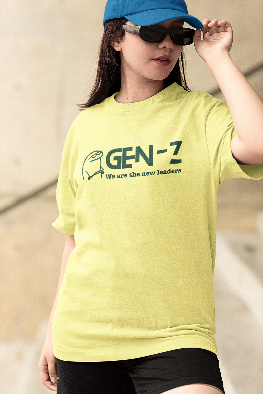 Person wearing a yellow 'GEN-Z' t-shirt with a blue cap and sunglasses.