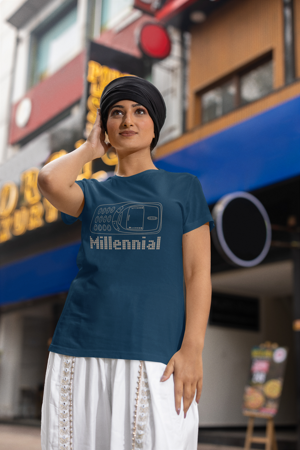 Woman wearing a blue t-shirt with 'Millennial' design in an urban setting