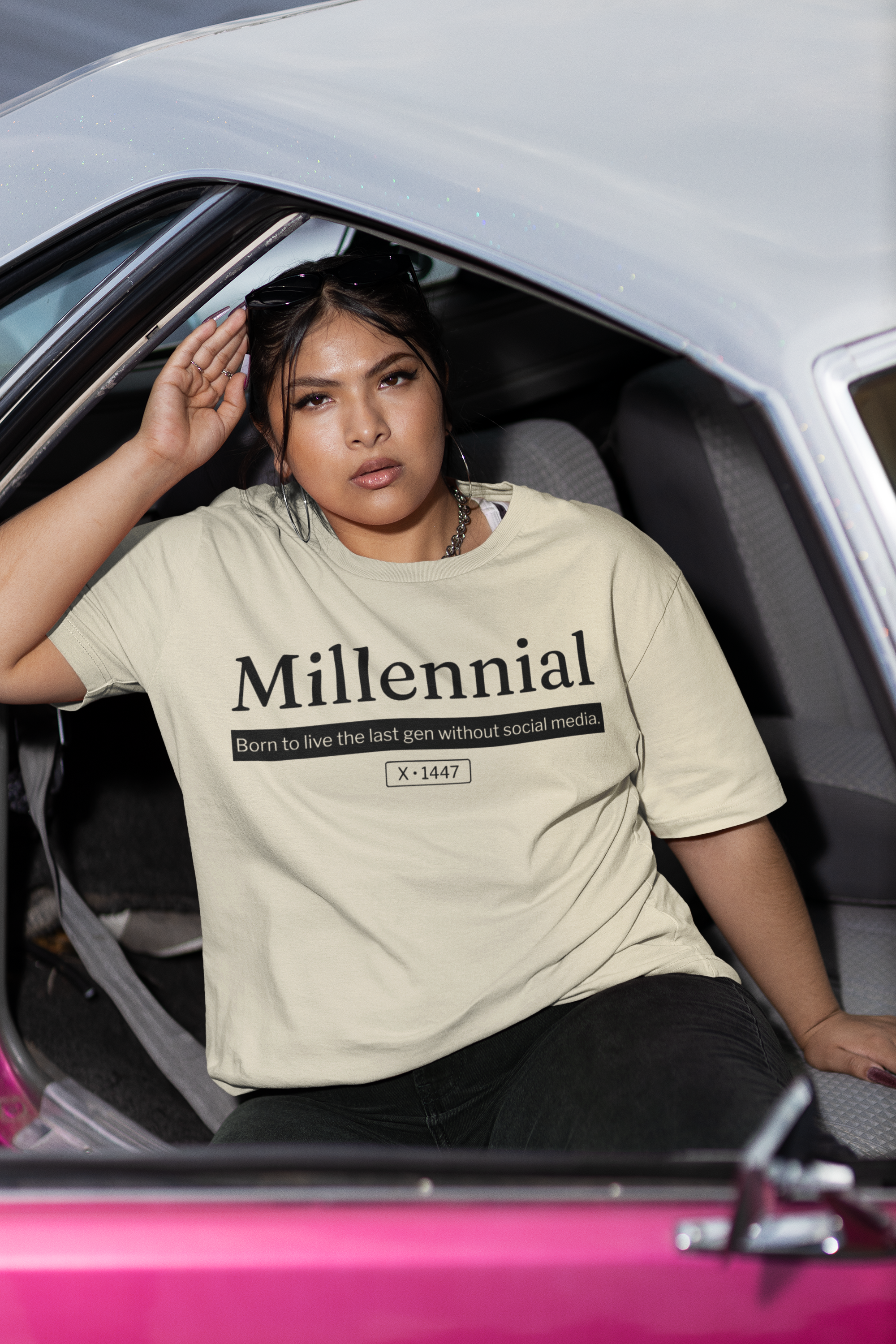 Person wearing a 'Millennial' t-shirt sitting inside a car.