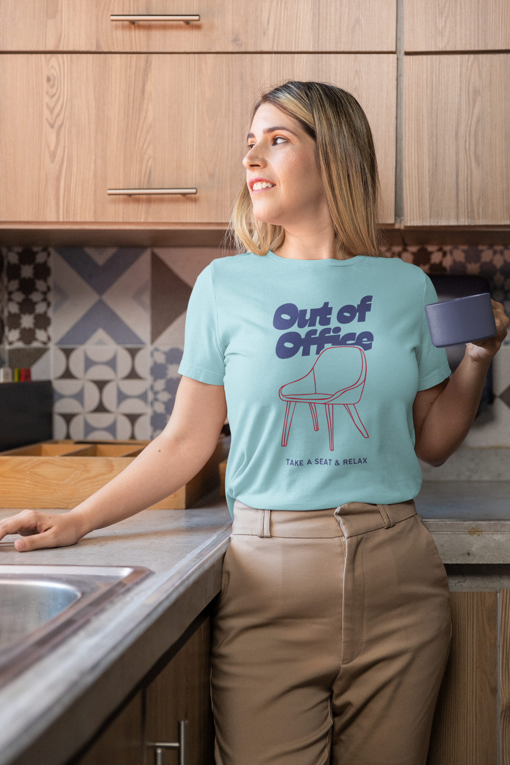 Woman wearing a 'Out of Office' t-shirt in a kitchen.
