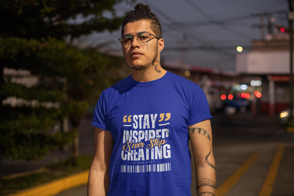 Man wearing a blue t-shirt with motivational text on a street at night.